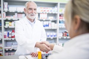 Pharmacist And Customer Shaking Hands In Pharmacy - Recuperação de Impostos | Planrec Gestão Tributária